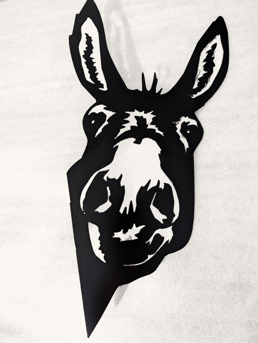 Black metal donkey head silhouette on a white background