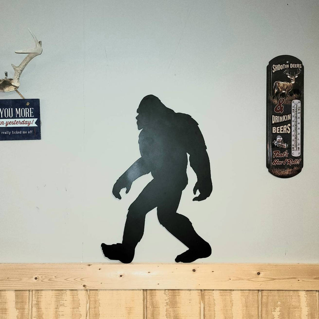 Bigfoot Metal Yard Art Metal Garden Stake — shown on a rustic wall