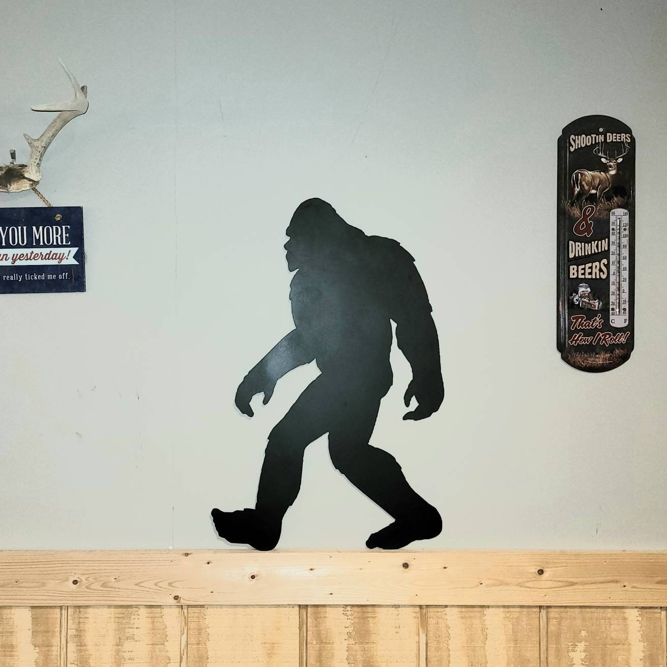 Bigfoot Metal Yard Art Metal Garden Stake — shown on a rustic wall