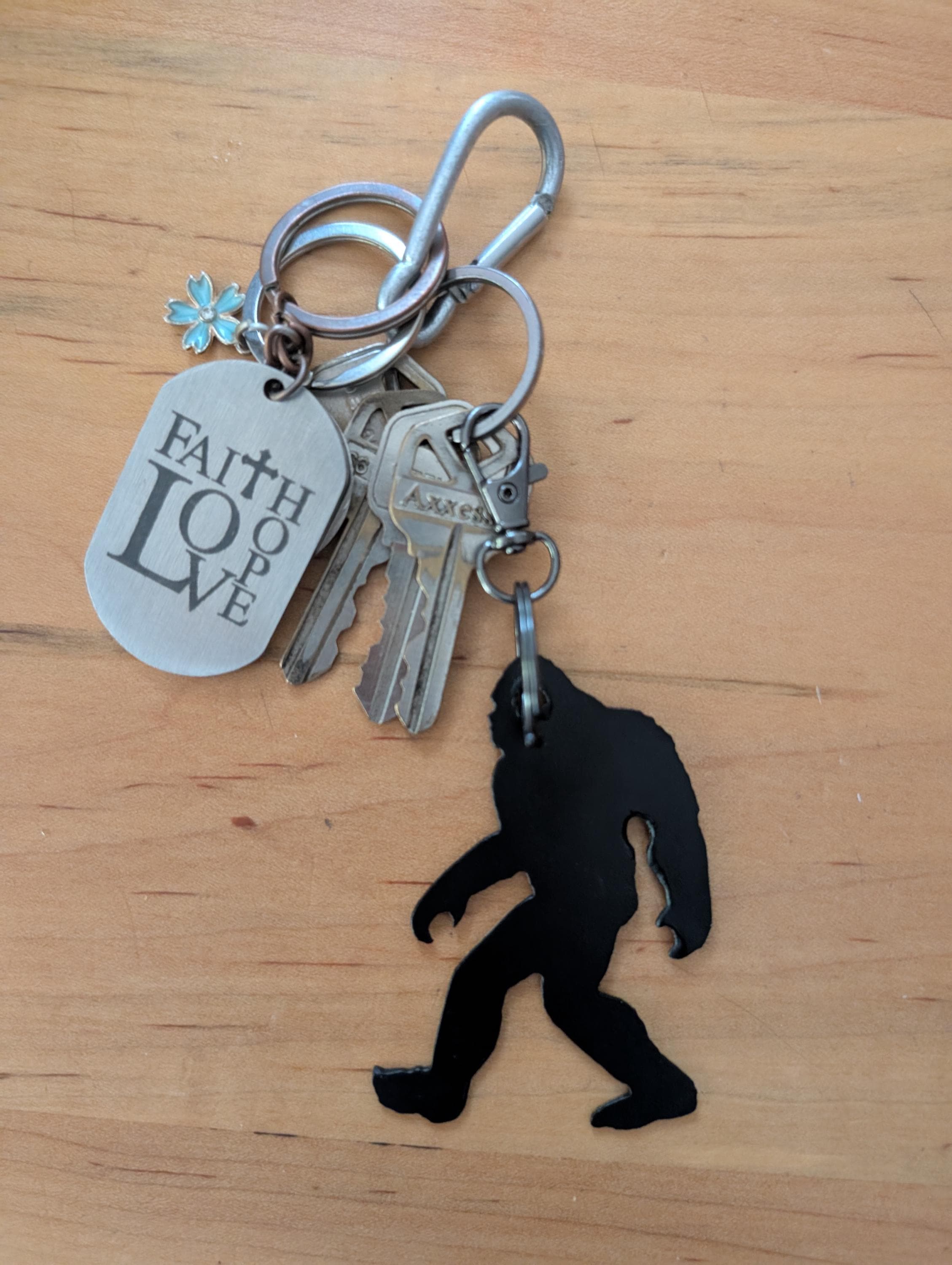 Bigfoot Metal Keychain Metal Keychain — shown on a rustic wall
