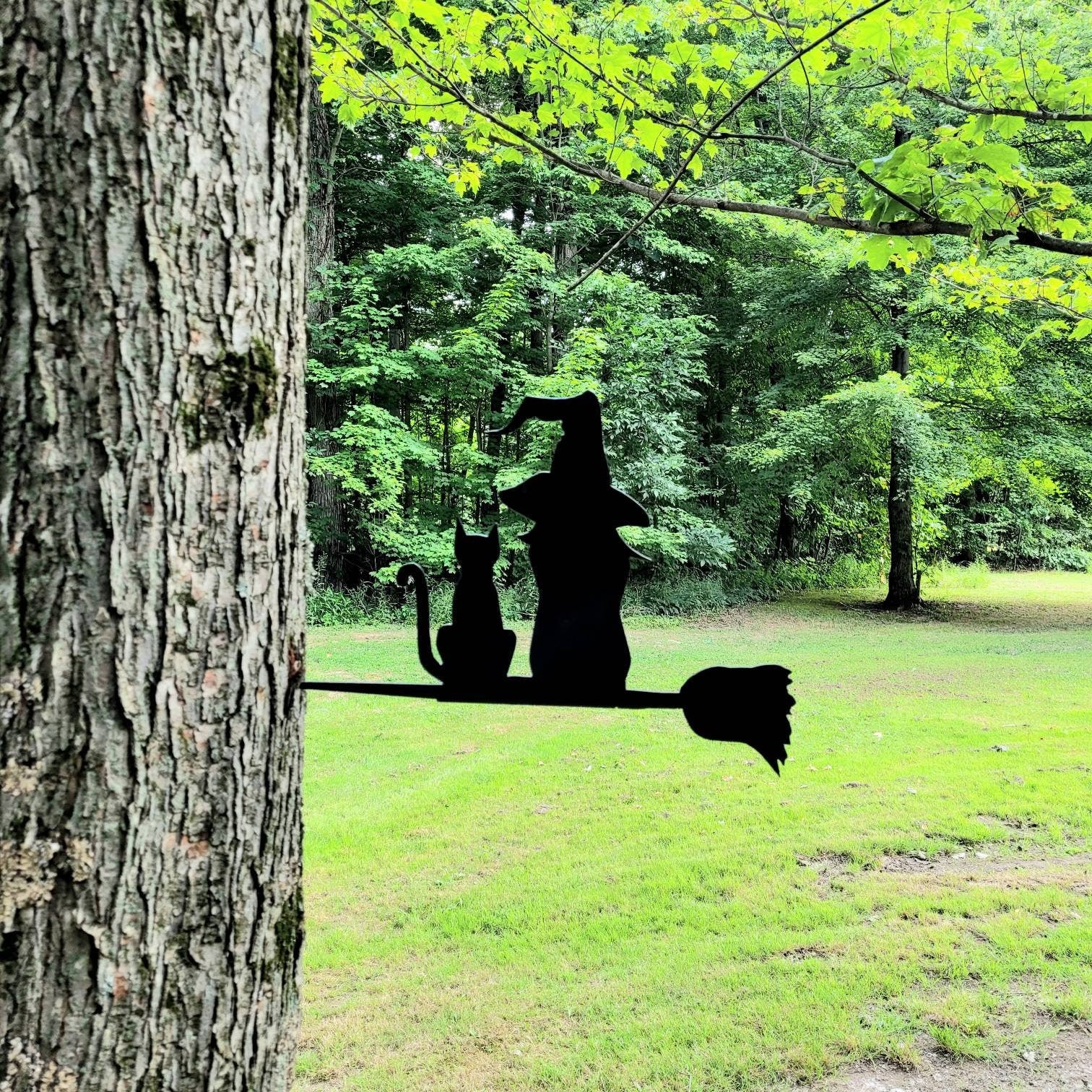 Witch and Cat Metal Garden Stake Metal Garden Stake — shown on a rustic wall