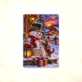 Aluminum sign showing a snowman in a top hat and plaid scarf with a kitten leaping onto his head, displayed flat against a plain background.