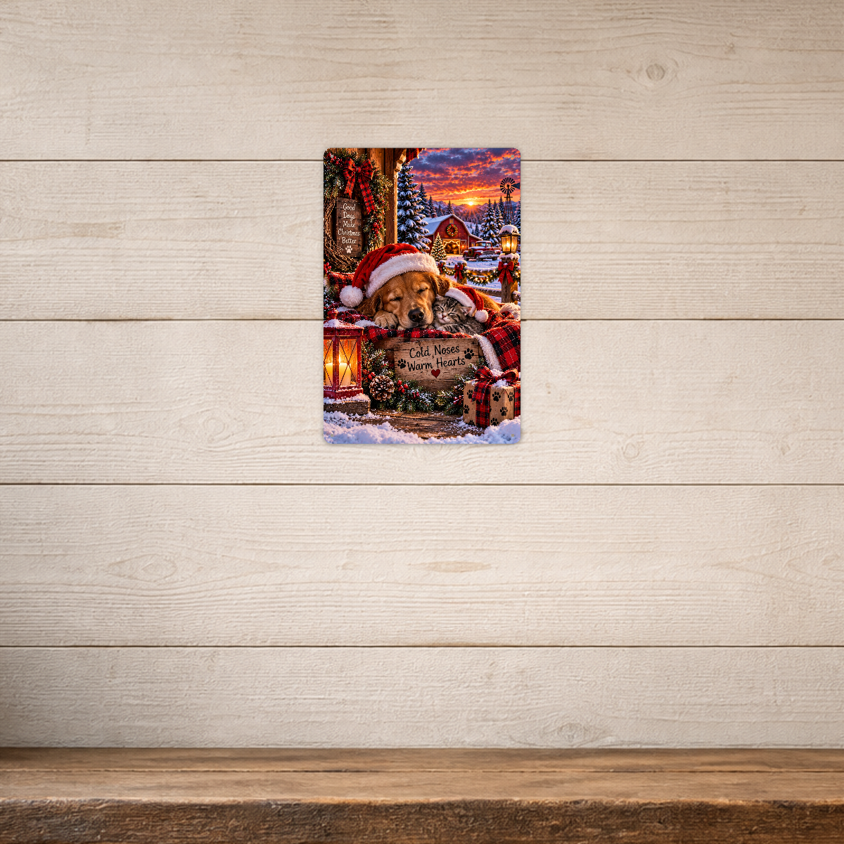 The aluminum sign showing a golden retriever and a kitten asleep together in Santa hats, mounted on a light shiplap-paneled wall.