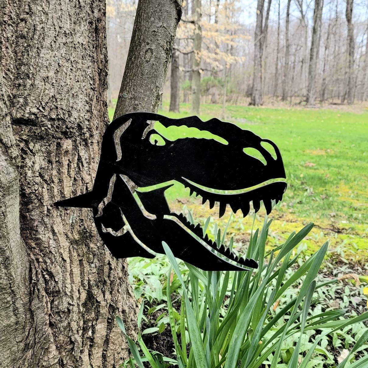 T-Rex Dinosaur Metal Garden Stake Metal Garden Stake — shown on a rustic wall