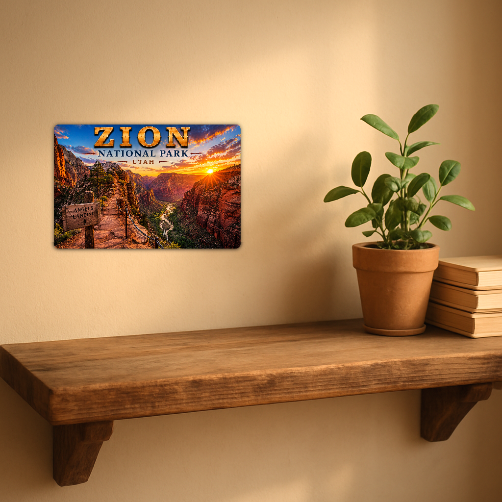 Zion Angels Landing sign with a path overlooking a red canyon and winding river at sunset, displayed on a warm beige wall above a wooden shelf with a potted plant and books.