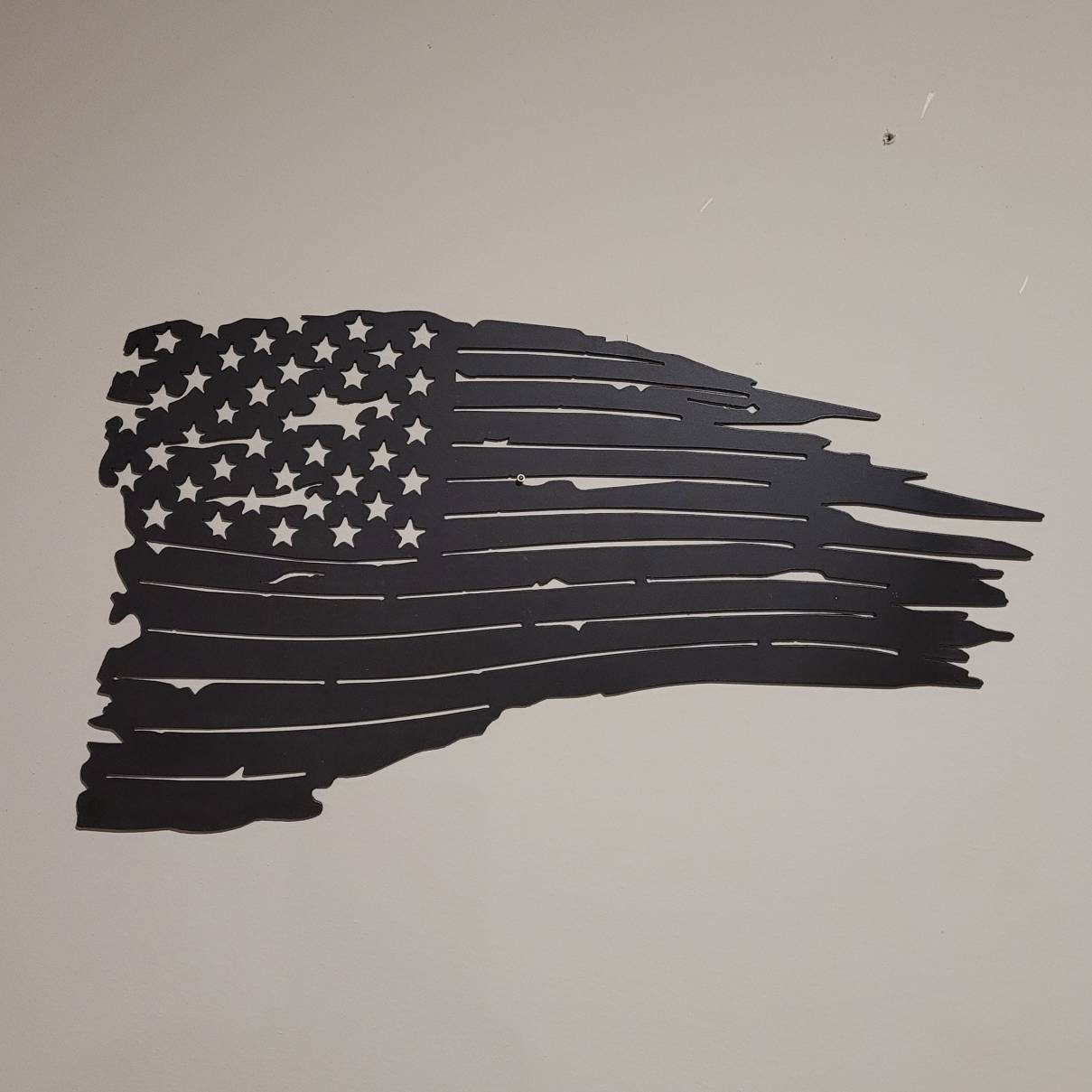 Distressed US Flag Patriotic Metal Sign Aluminum Sign — shown on a rustic wall
