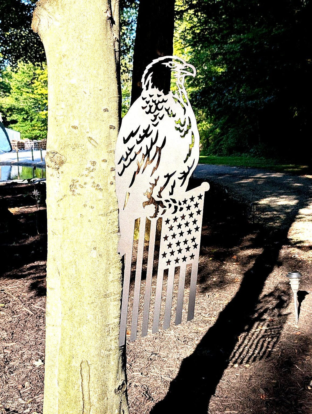 Eagle American Flag Garden Stake Metal Garden Stake — shown on a rustic wall