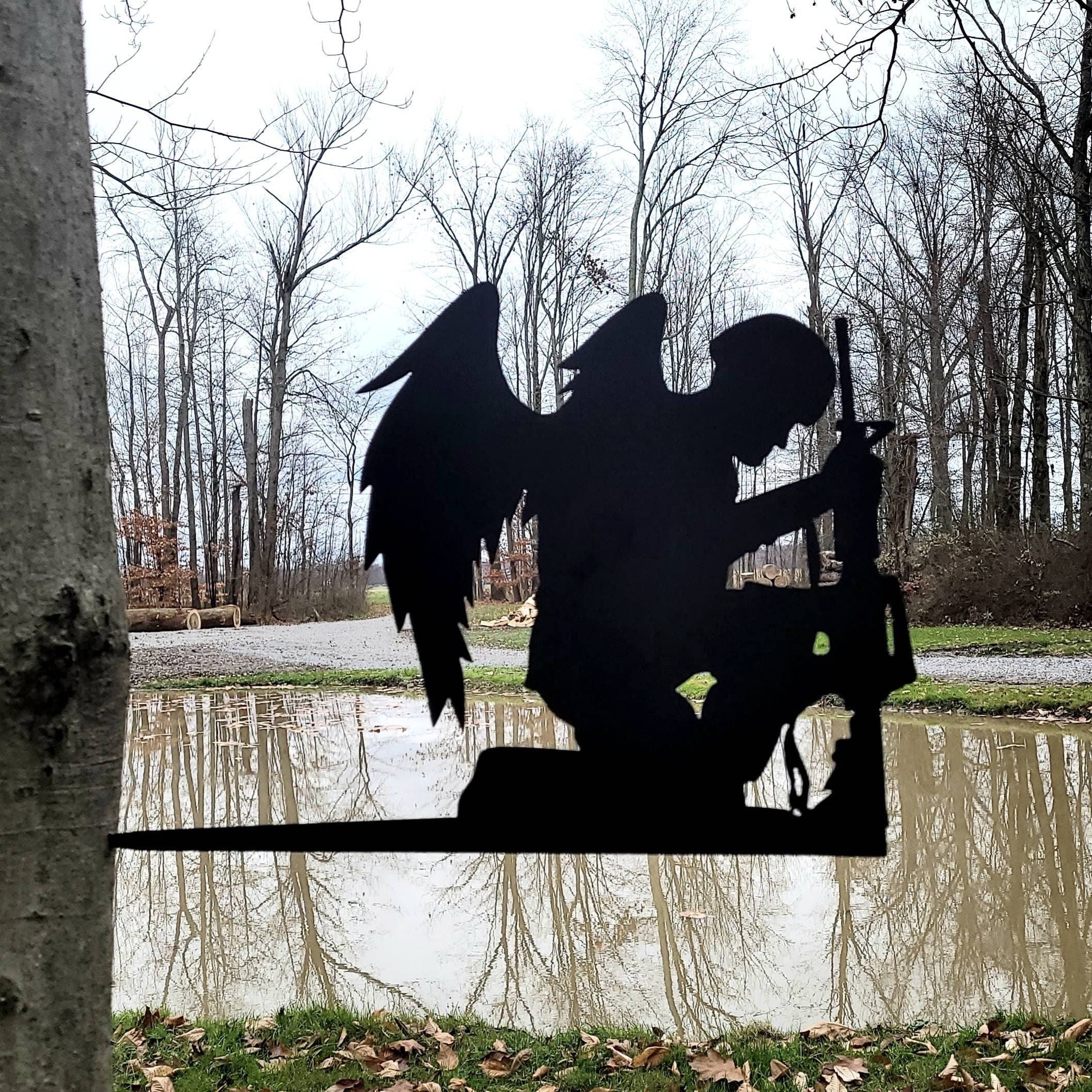 Fallen Soldier Angel Garden Stake Metal Garden Stake — shown on a rustic wall