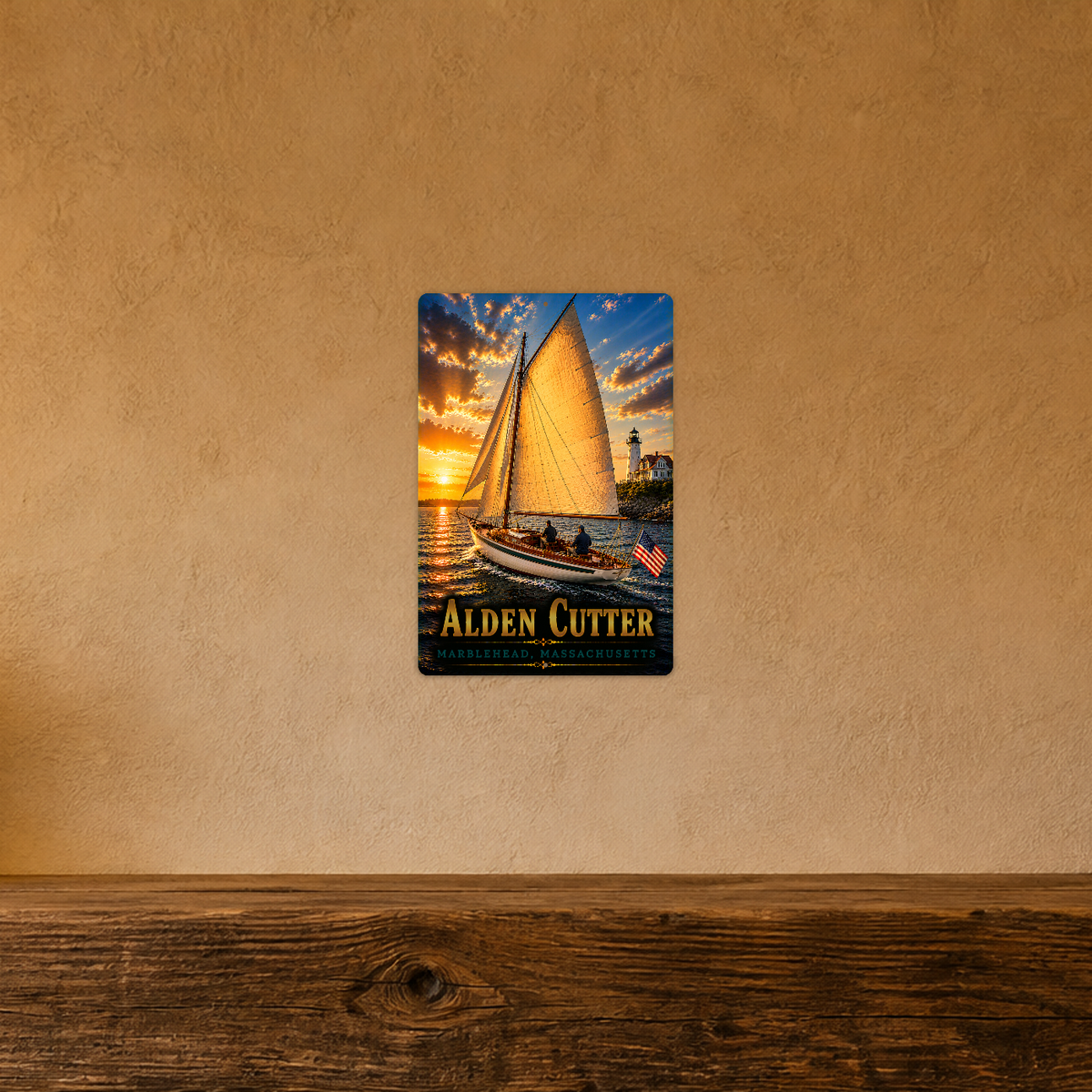 Sign showing Alden Cutter lettering and a sailboat with golden sails near a lighthouse, displayed on a warm tan textured wall above a wooden ledge.