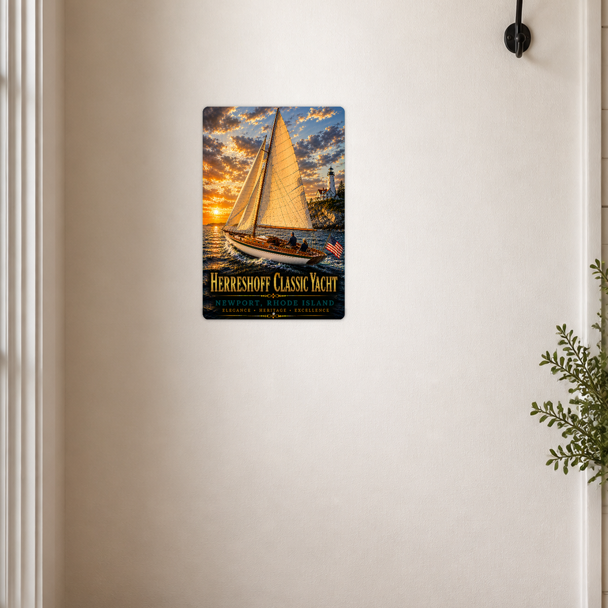 Sign showing Herreshoff Classic Yacht Newport lettering and a golden-sailed boat with an American flag, displayed on a cream wall beside a white-framed doorway and black fixture.