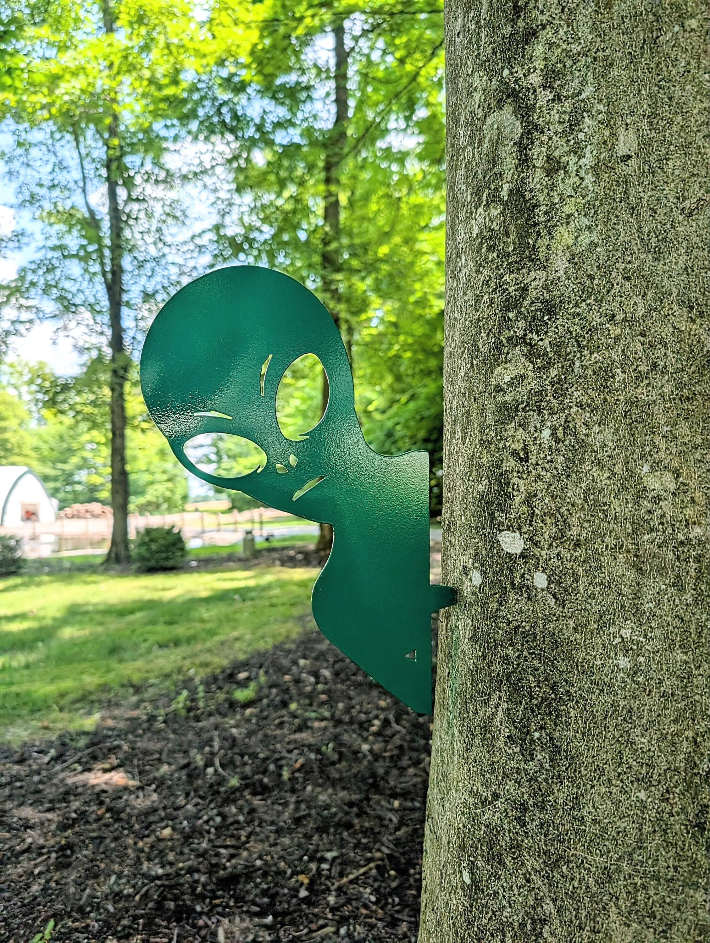 Alien Metal Garden Stake Metal Garden Stake — shown on a rustic wall