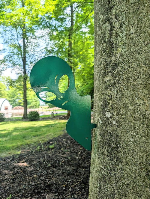 Alien Metal Garden Stake Metal Garden Stake — shown on a rustic wall