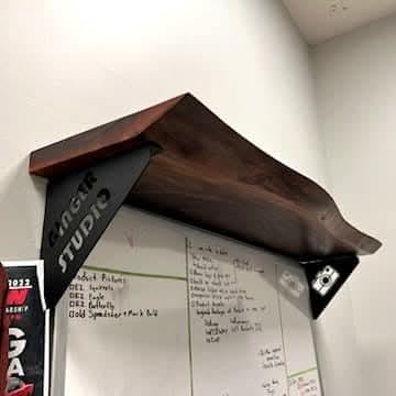 Bear Shelf Bracket Metal Shelf Bracket — shown on a rustic wall
