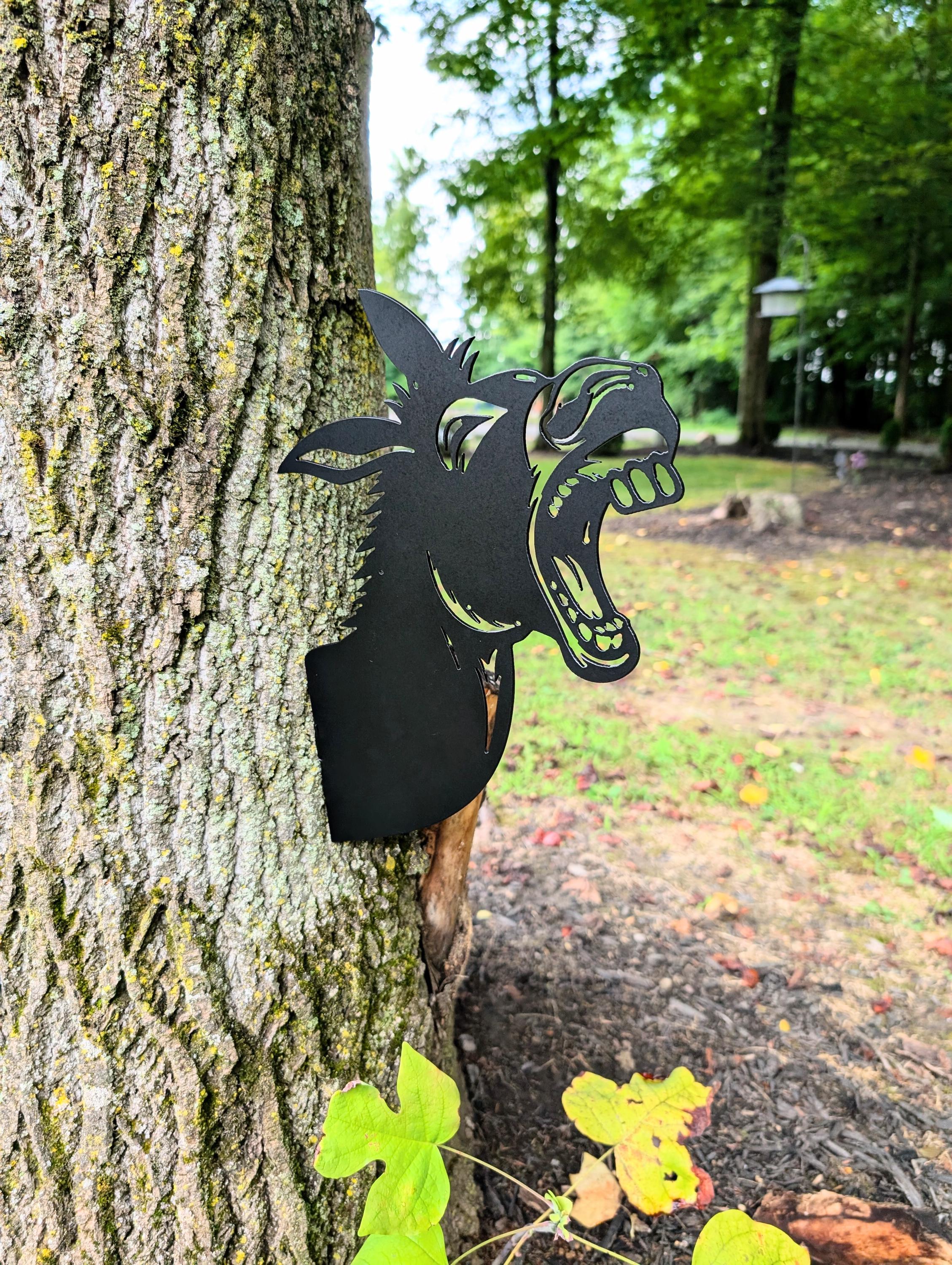 Laughing Donkey Metal Yard Stake Metal Garden Stake — shown on a rustic wall