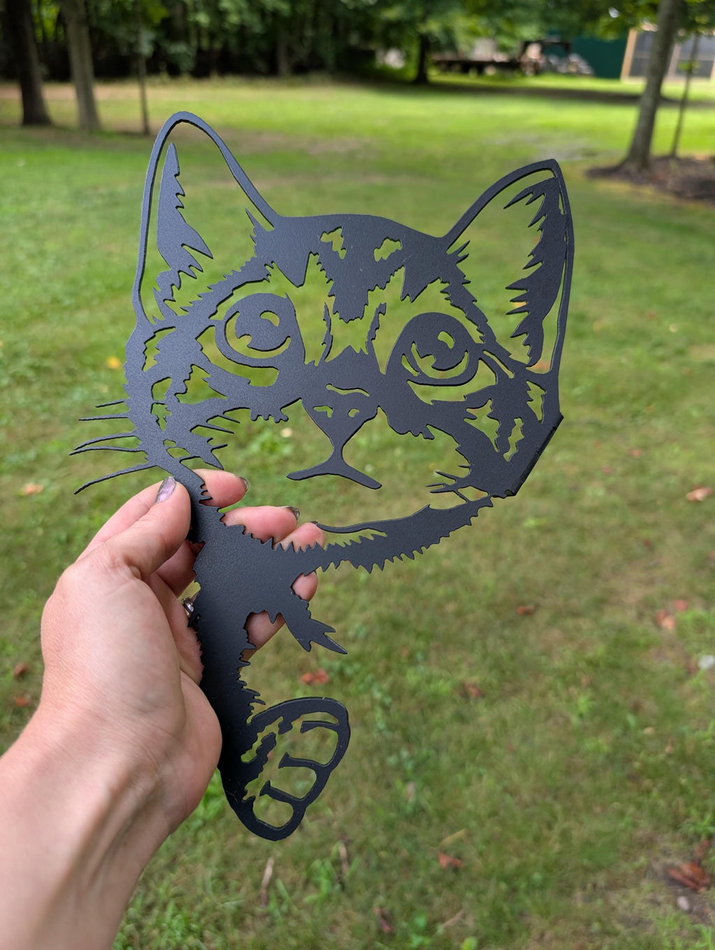 Peeking Black Cat Metal Yard Art Metal Garden Stake — shown on a rustic wall