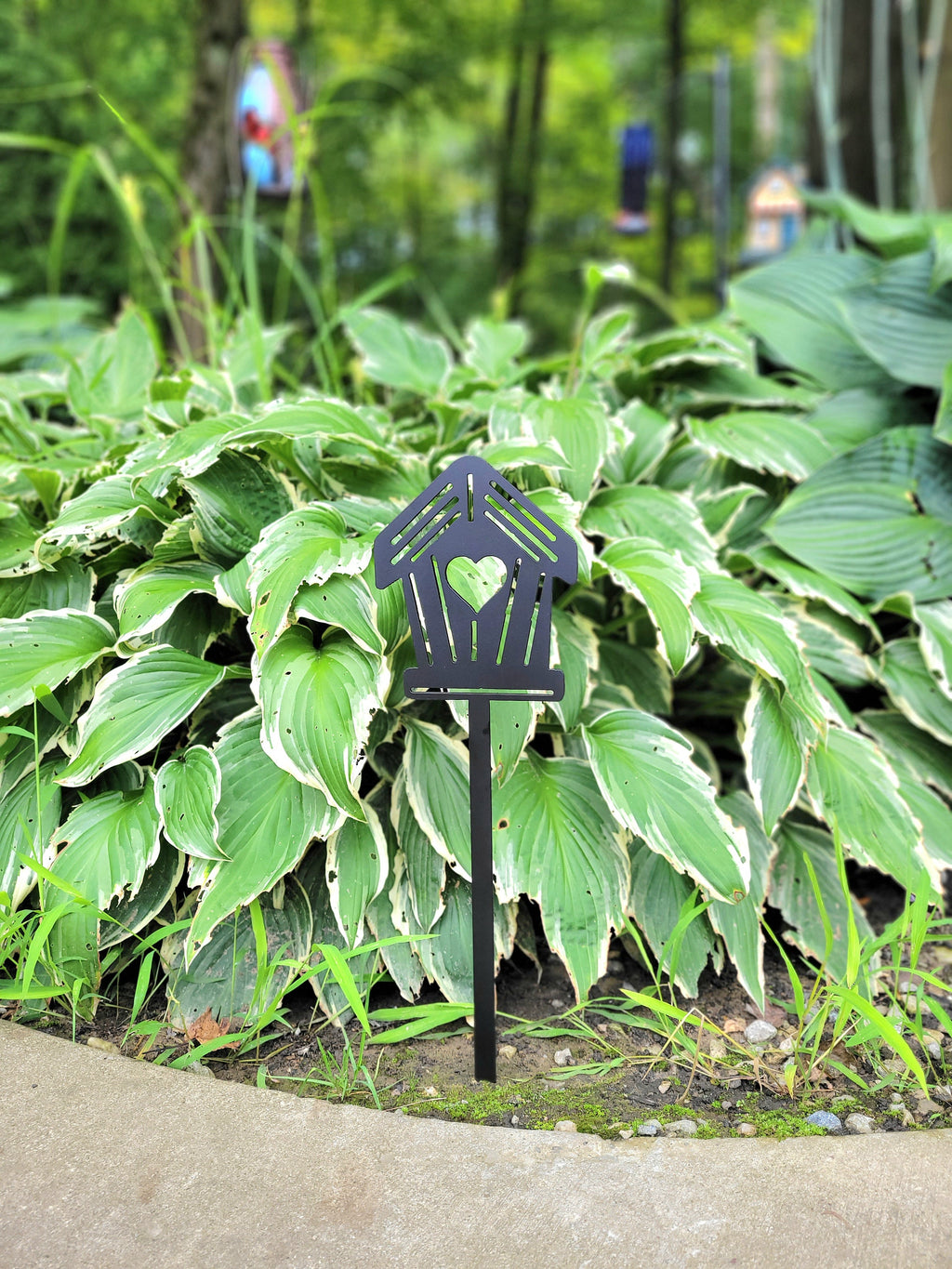 Birdhouse Metal Garden Stake Metal Garden Stake — shown on a rustic wall