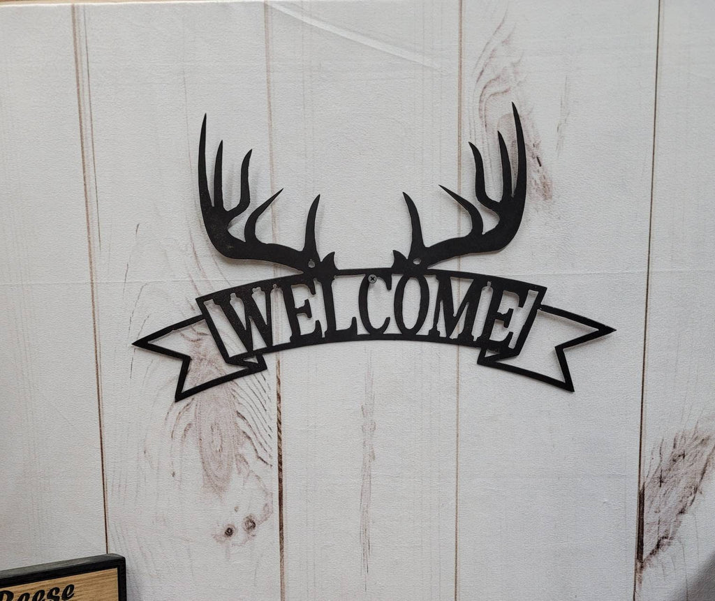 Deer Antler Welcome Garden Stake Metal Garden Stake — shown on a rustic wall