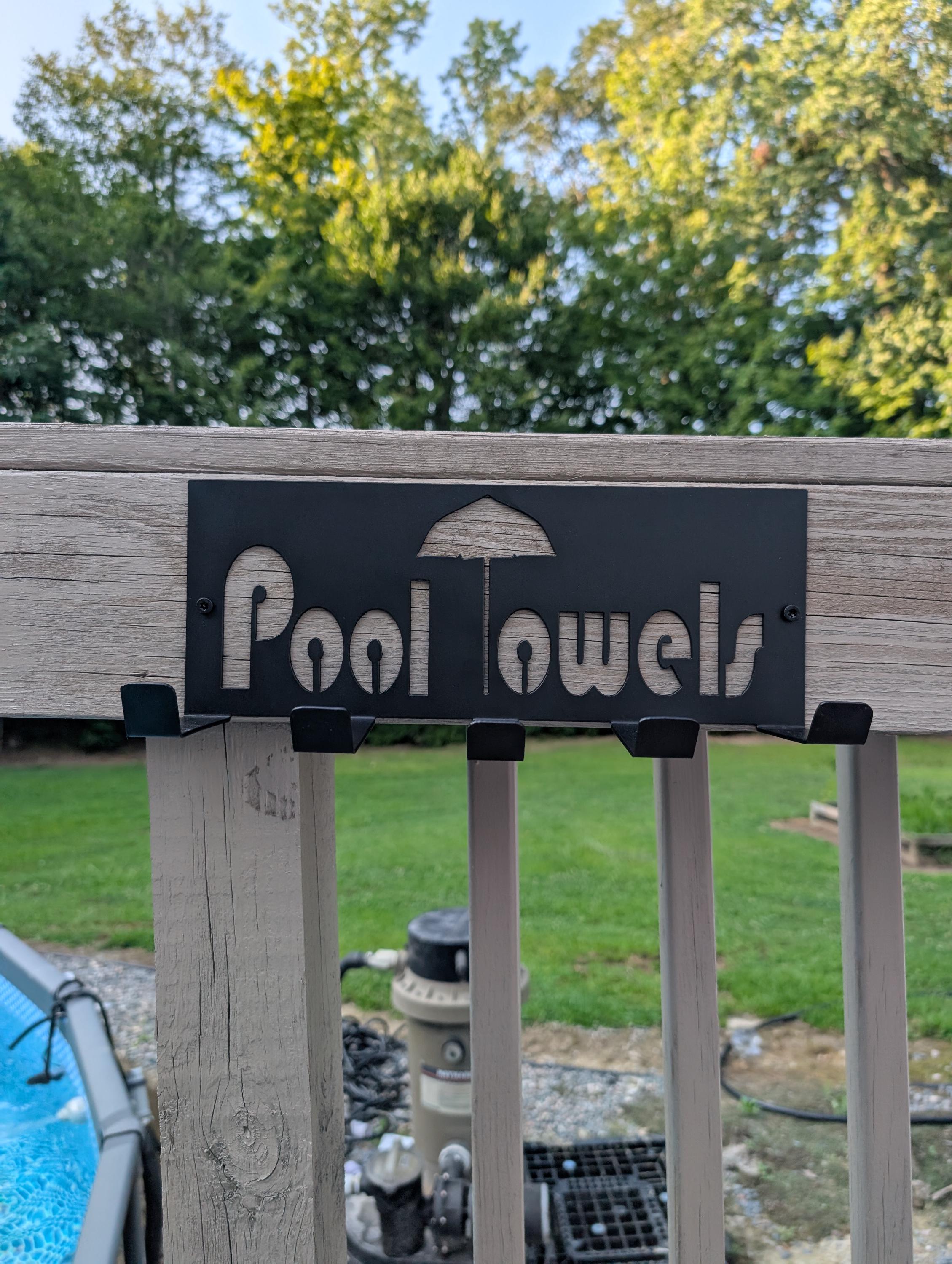 Pool Towel Hanger Aluminum Sign — shown on a rustic wall
