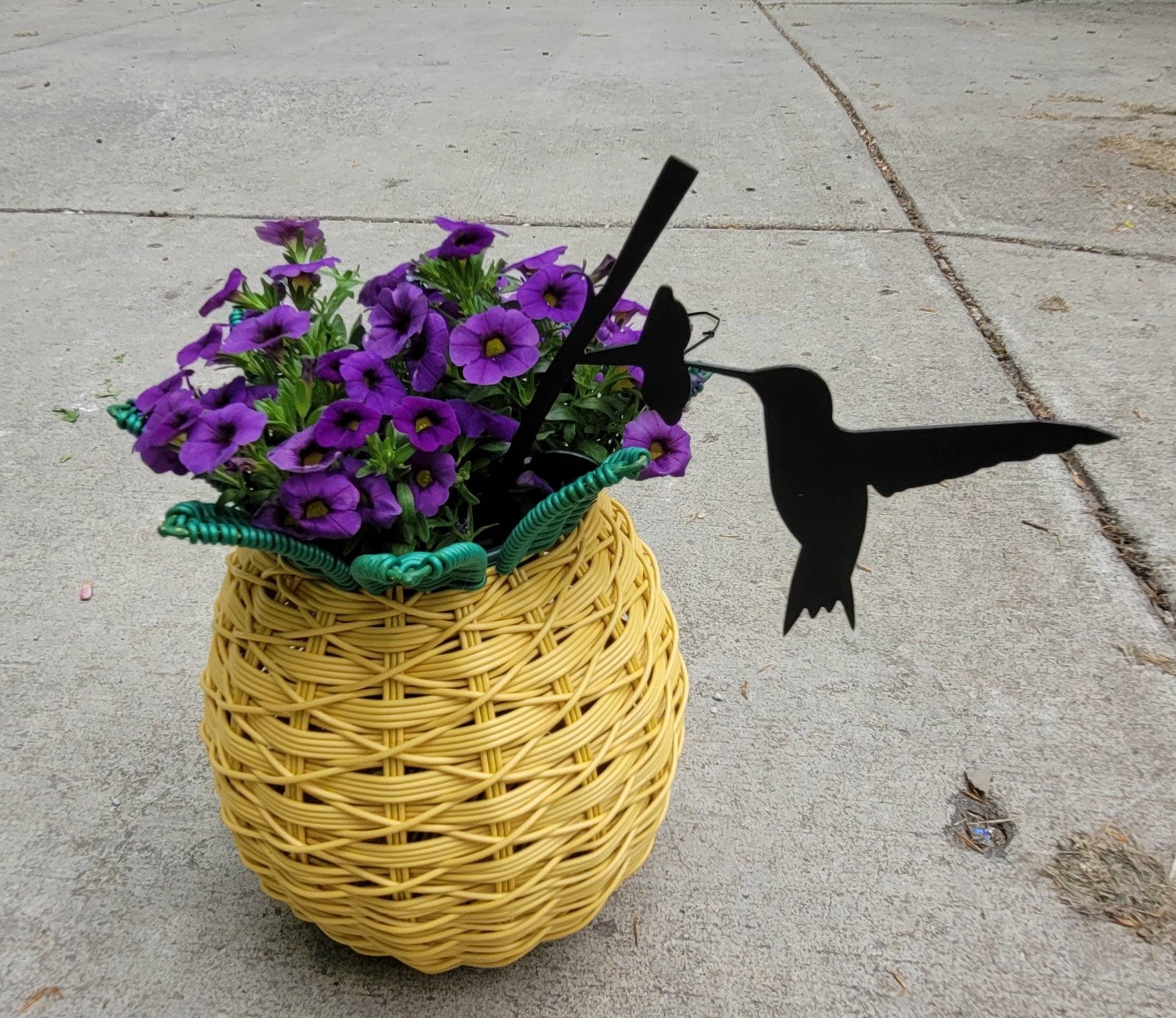 Hummingbird Metal Garden Stake Metal Garden Stake — shown on a rustic wall