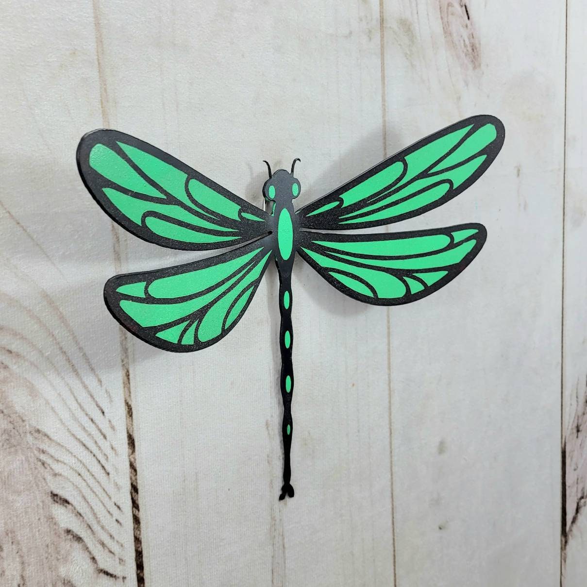 Painted Dragonfly Metal Wall Art Metal Garden Stake — shown on a rustic wall