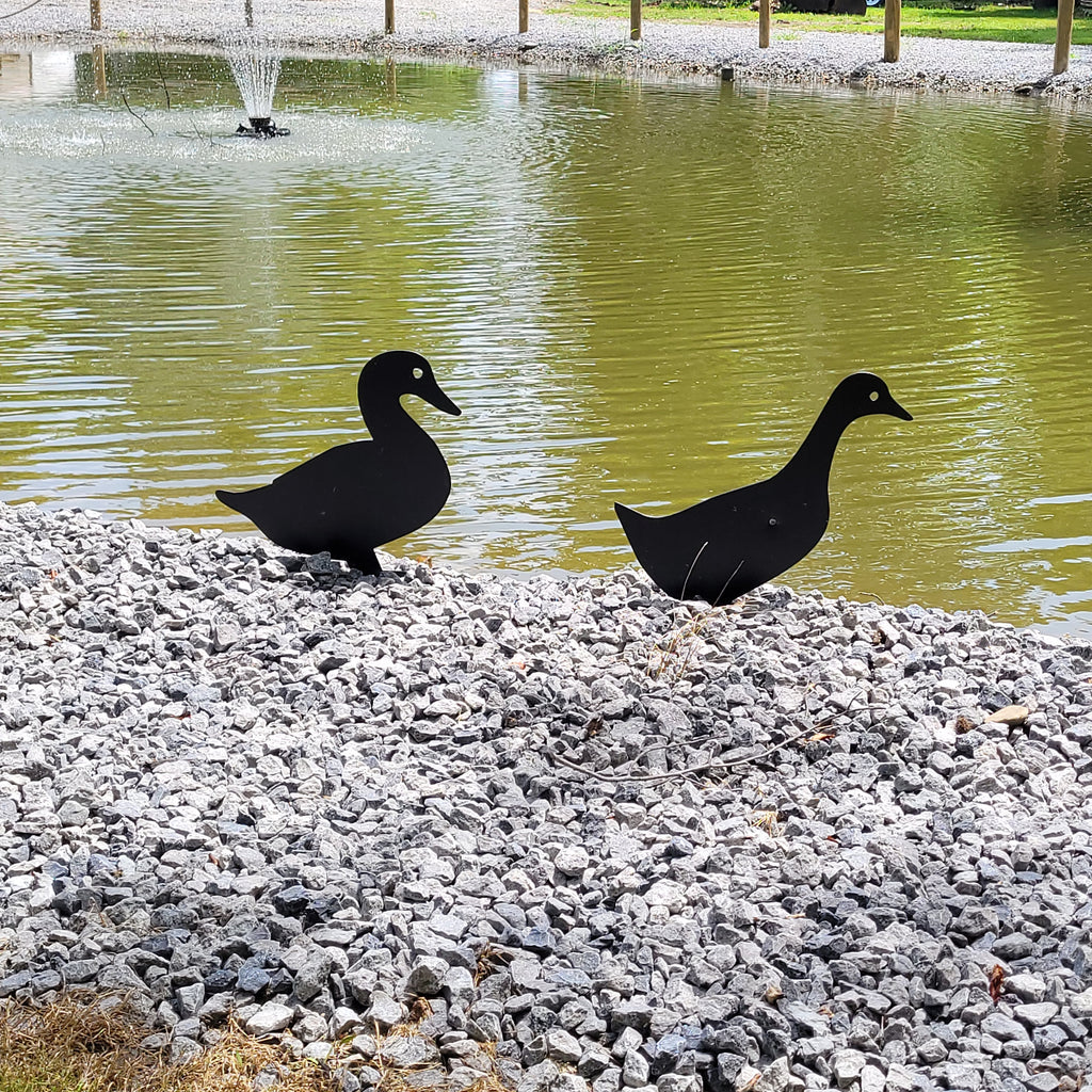 Duck Pair Metal Garden Stake Metal Garden Stake — shown on a rustic wall