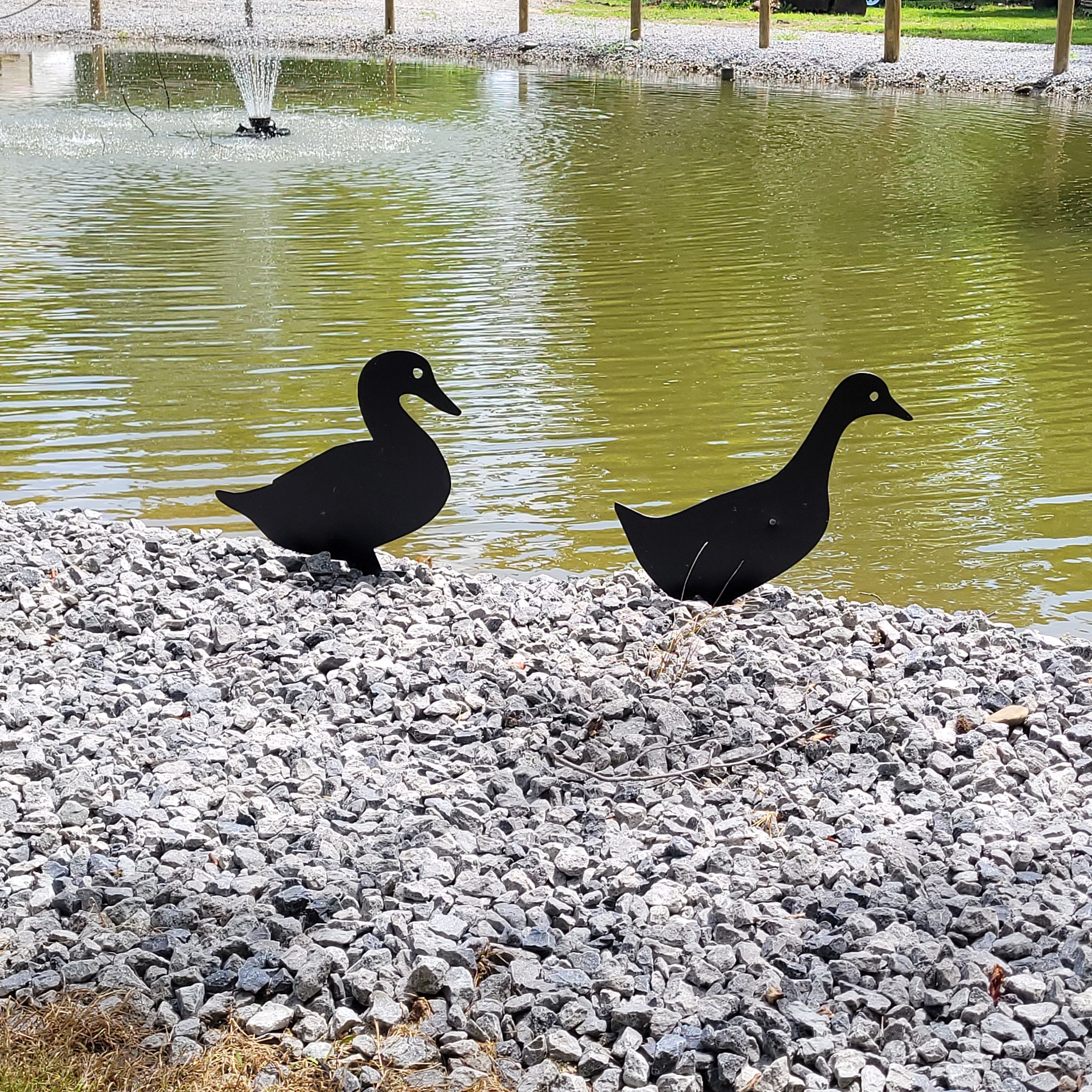 Duck Pair Metal Garden Stake Metal Garden Stake — shown on a rustic wall