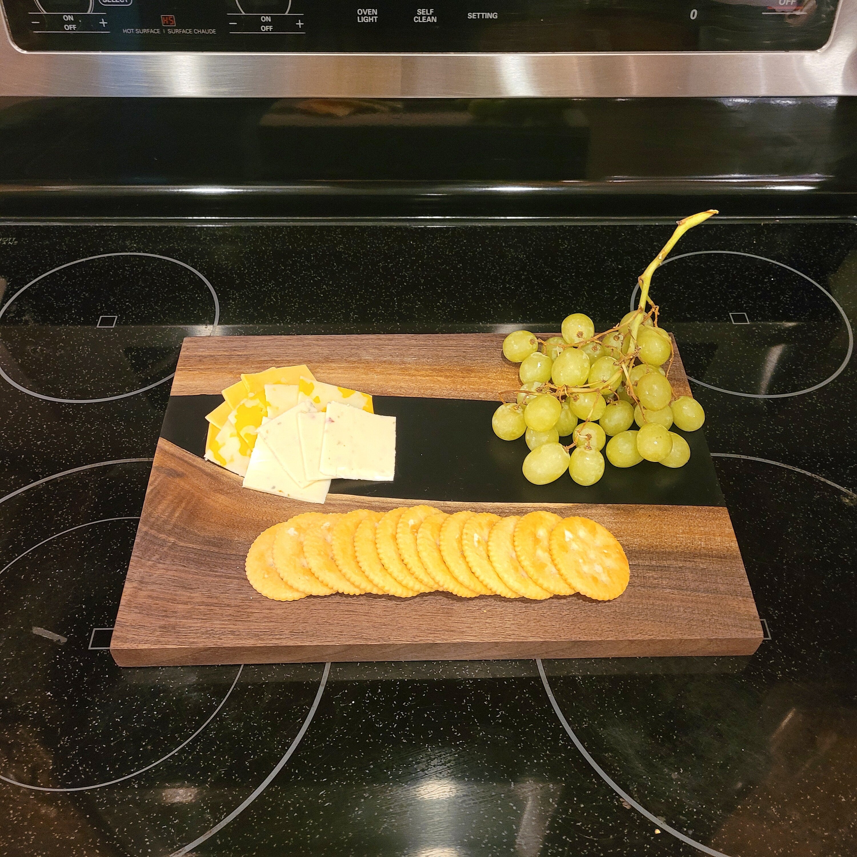 Live Edge Walnut Charcuterie Board: Black Epo Wood Sign — shown on a rustic wall
