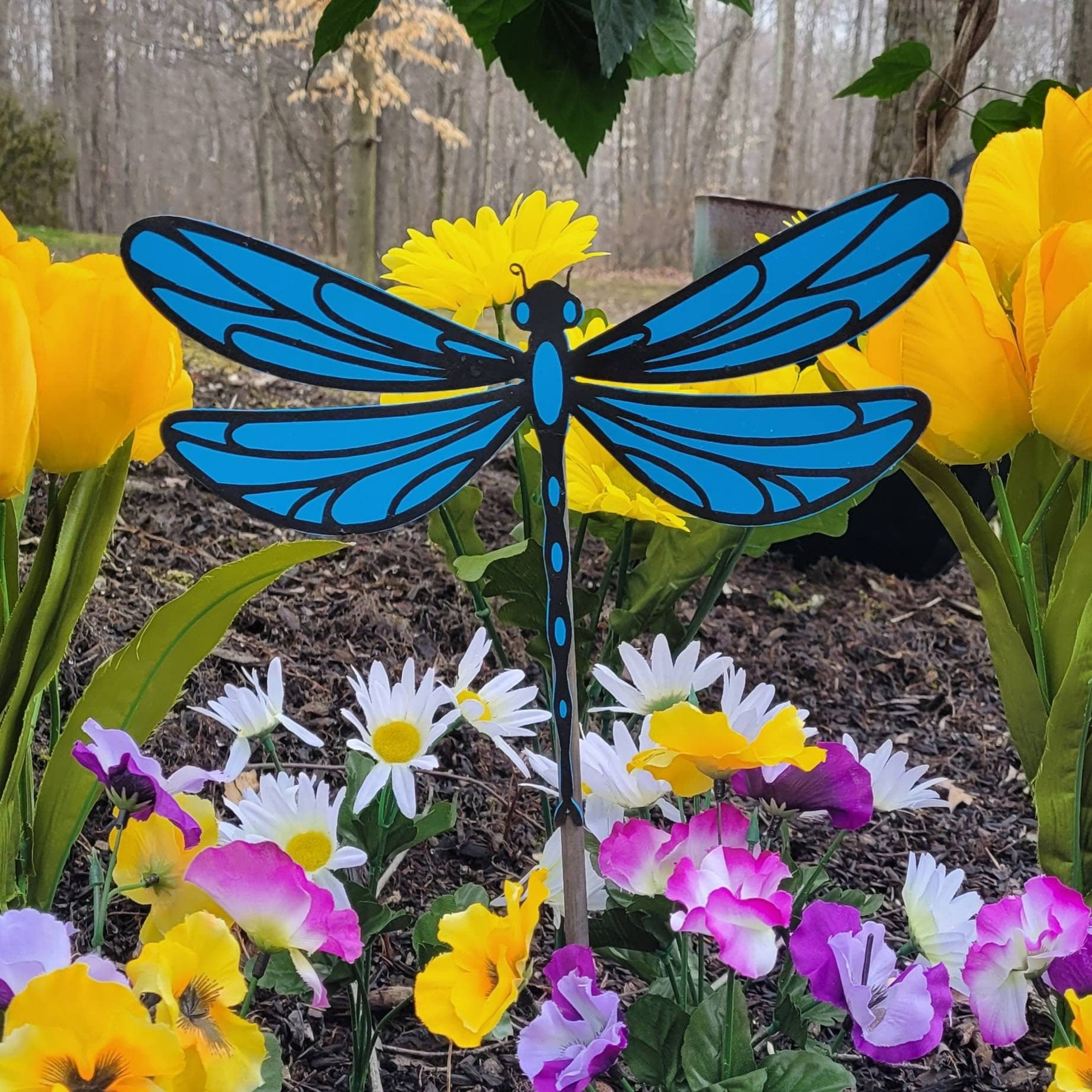 Dragonfly garden stake Metal Garden Stake — shown on a rustic wall