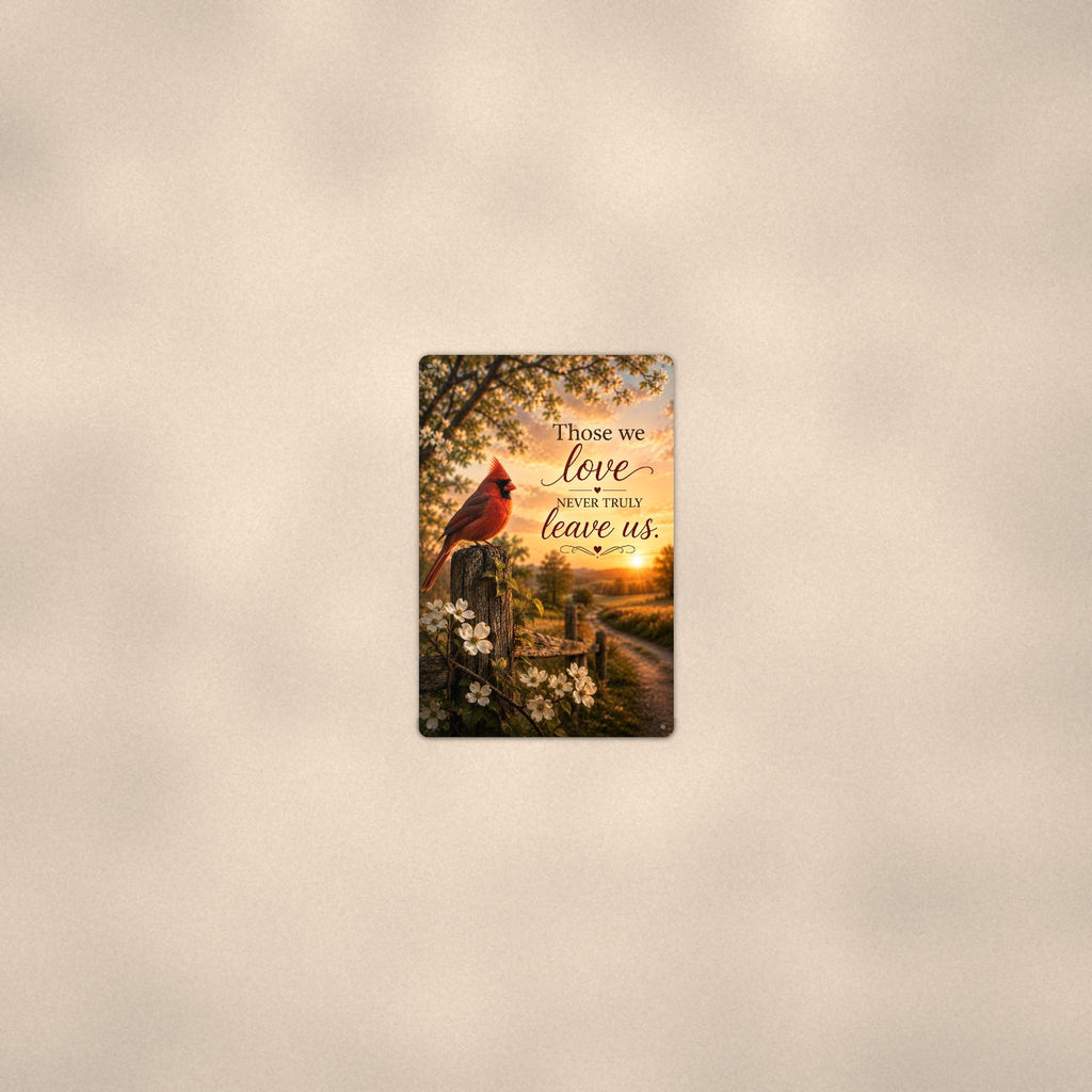 Red cardinal on a blossoming fence post memorial art titled "Those we love never truly leave us" on a 8x12 inch sublimated aluminum sign with rounded corners and mounting holes, seen from farther back, small on a softly lit wall