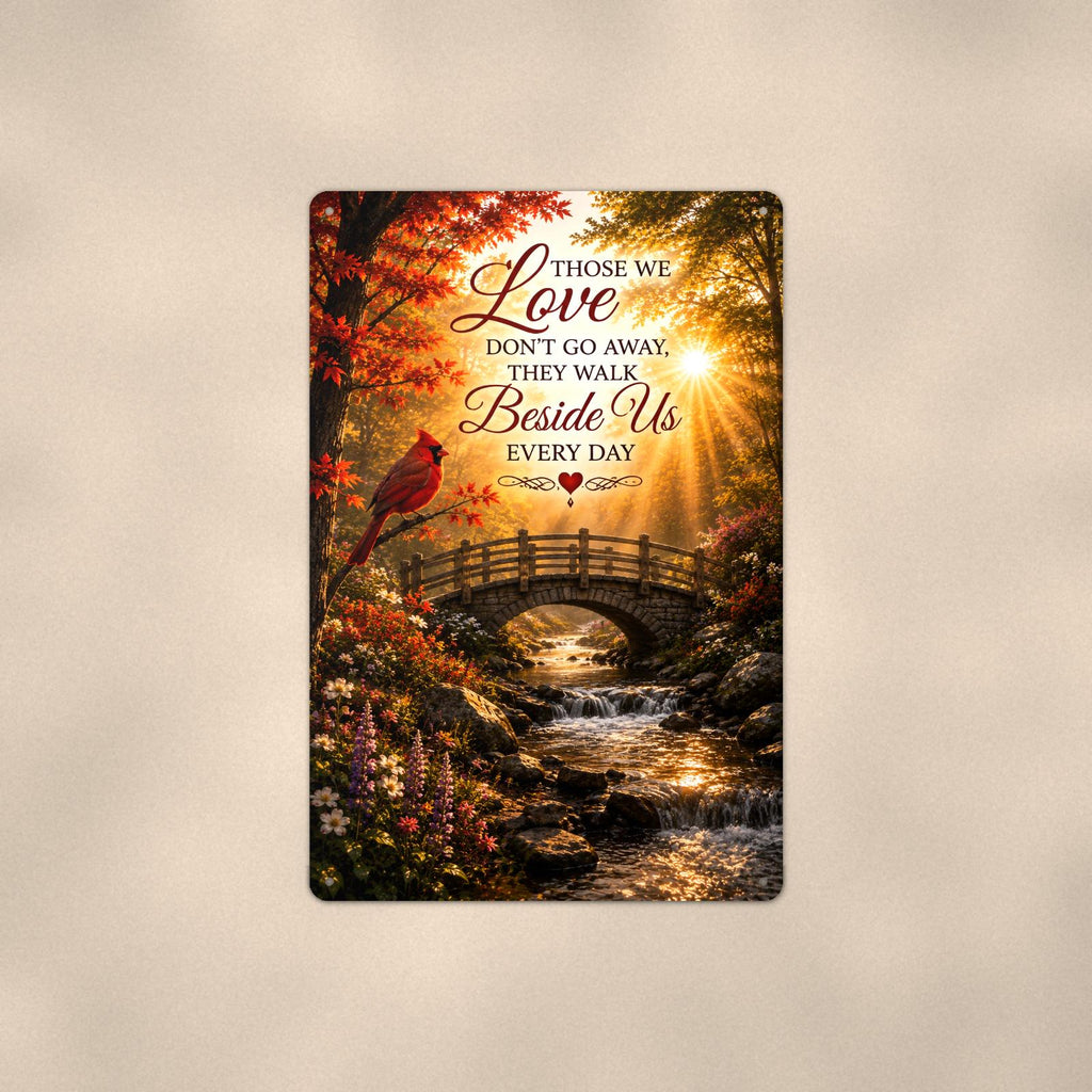 Cardinal over an autumn stream bridge memorial art titled "Those we Love don't go away, they walk Beside Us every day" on a 8x12 inch sublimated aluminum sign with rounded corners and mounting holes, shown straight on against a second warm wall tone