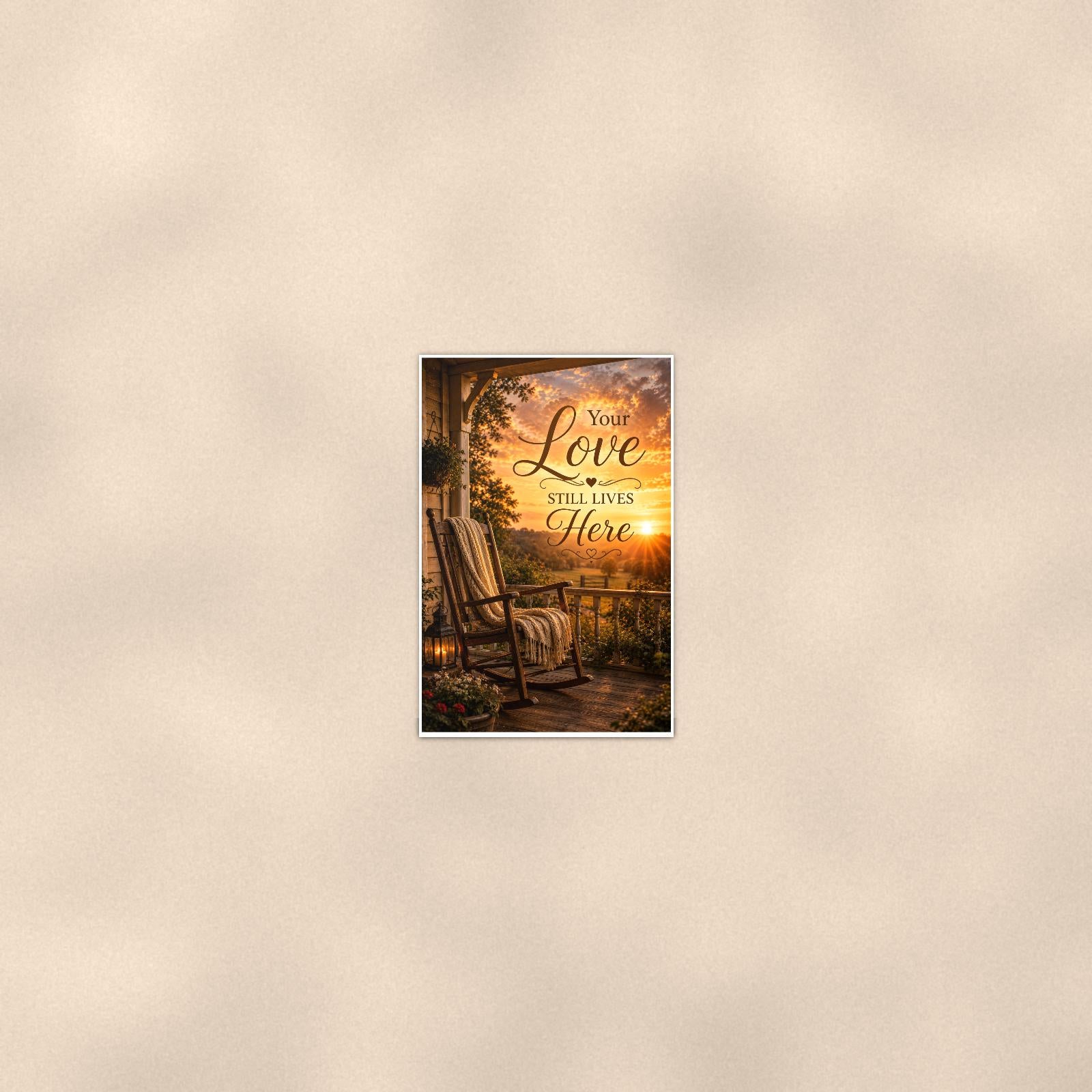 Rocking chair on the porch at sunset memorial art titled "Your Love Still Lives Here" on a 24x36 inch luster poster print with a clean white border, seen from farther back, small on a softly lit wall