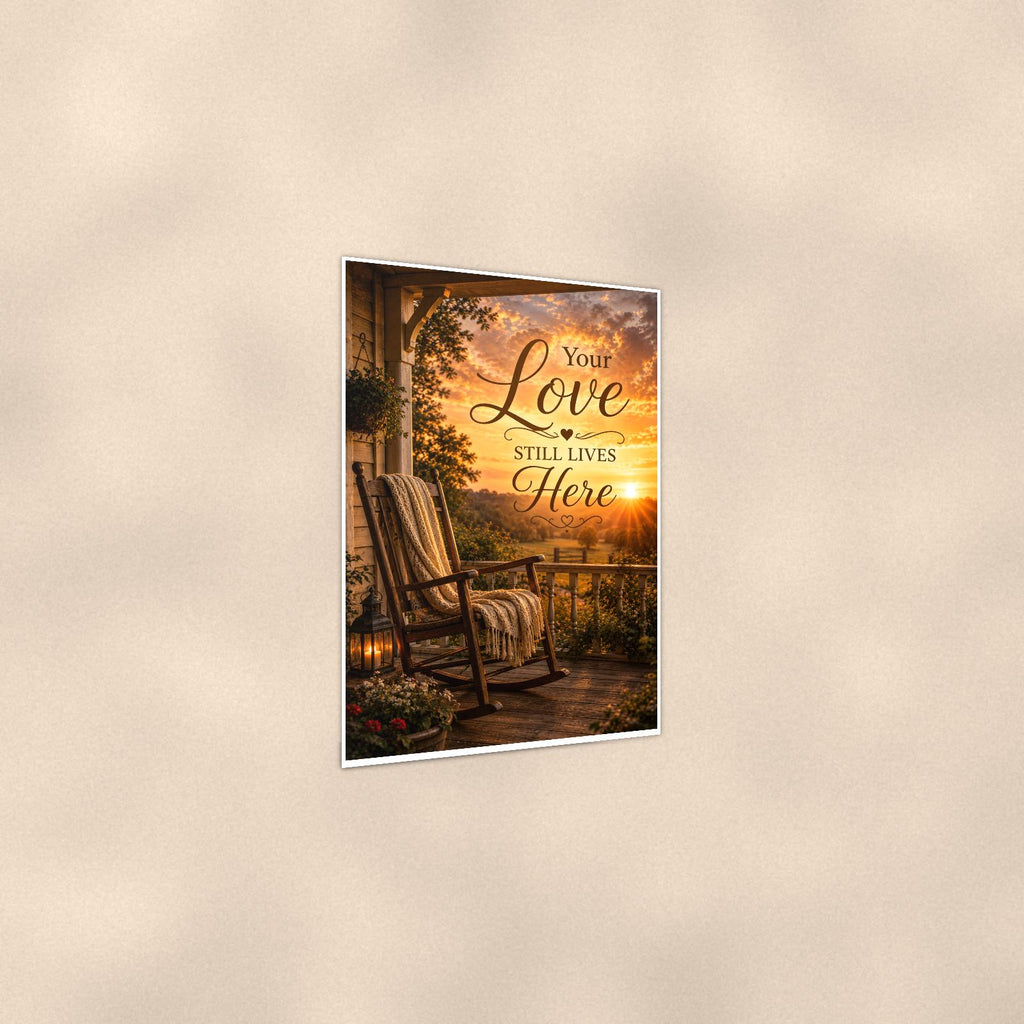 Rocking chair on the porch at sunset memorial art titled "Your Love Still Lives Here" on a 24x36 inch luster poster print with a clean white border, shown at a three-quarter angle on the wall