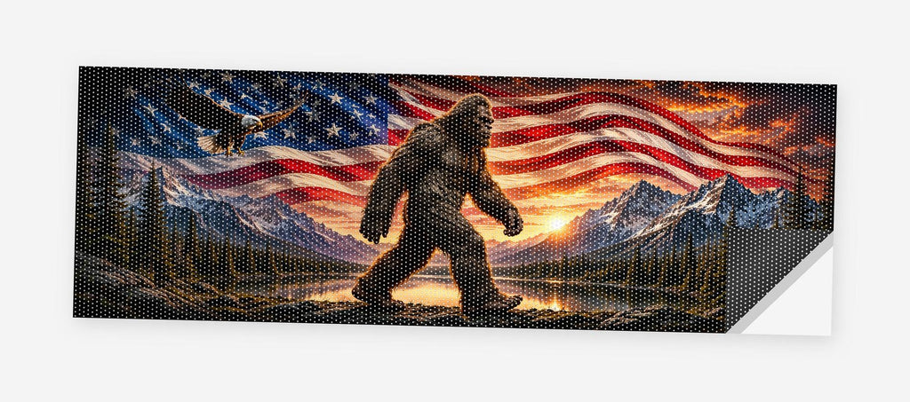 Full flat view of the Bigfoot American Flag perforated truck window decal on a white background, one corner curled to show the black perf-vinyl backing and the micro-hole pattern