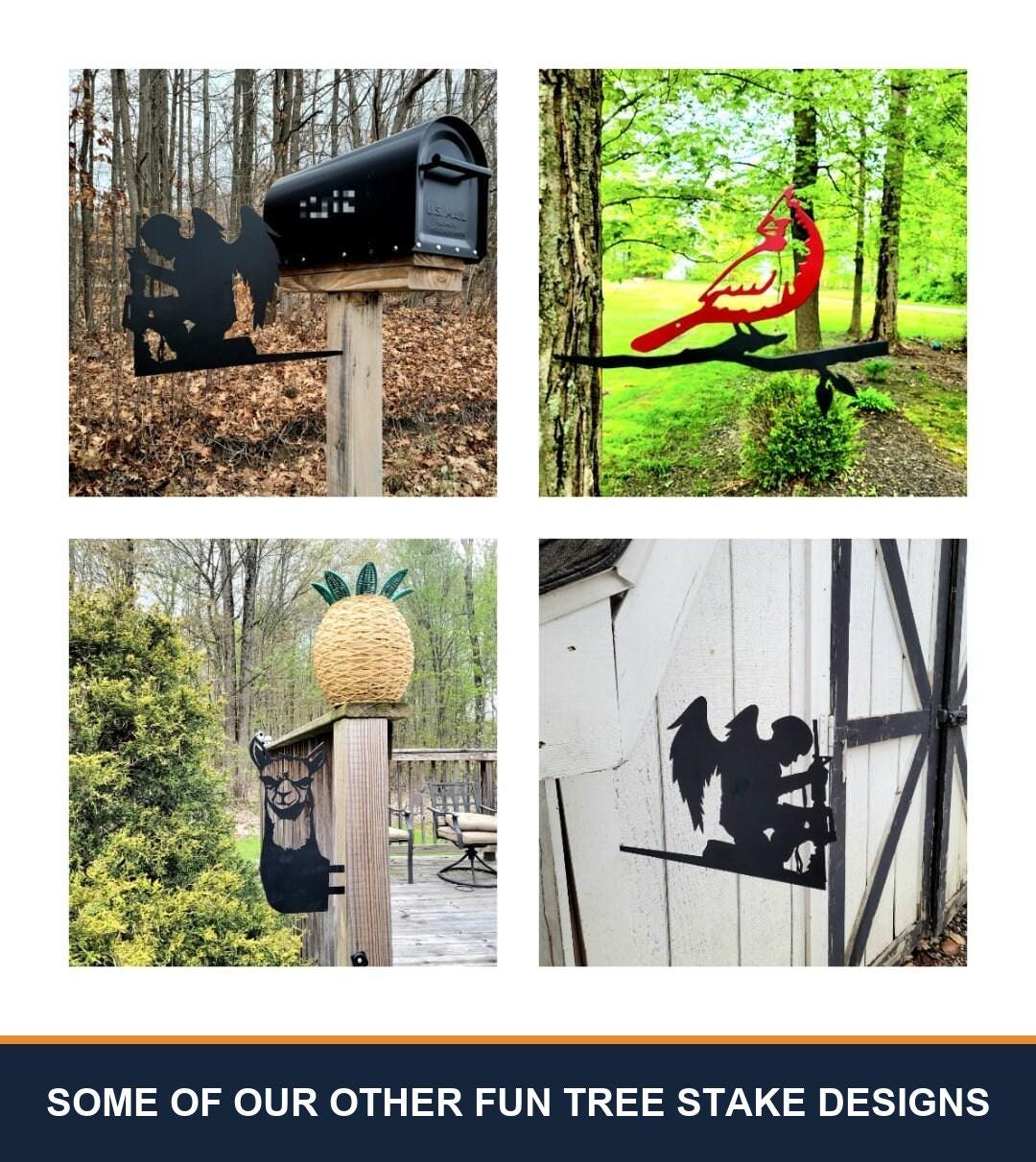 A sampler grid of other TKG metal tree and garden stake designs, shown staked in flower beds and mounted on trees, posts and mailboxes. Captioned “some of our other fun tree stake designs” — these are other designs we make, not what is included with this listing.
