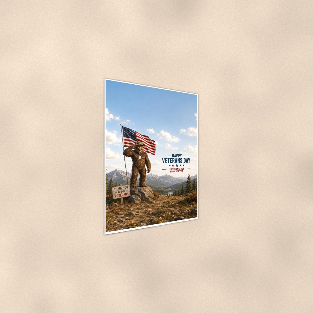 Veterans Day Bigfoot — 24x36 in art print poster, premium luster paper with a white border; steeper three-quarter angle on a warm wall, catching the luster sheen.