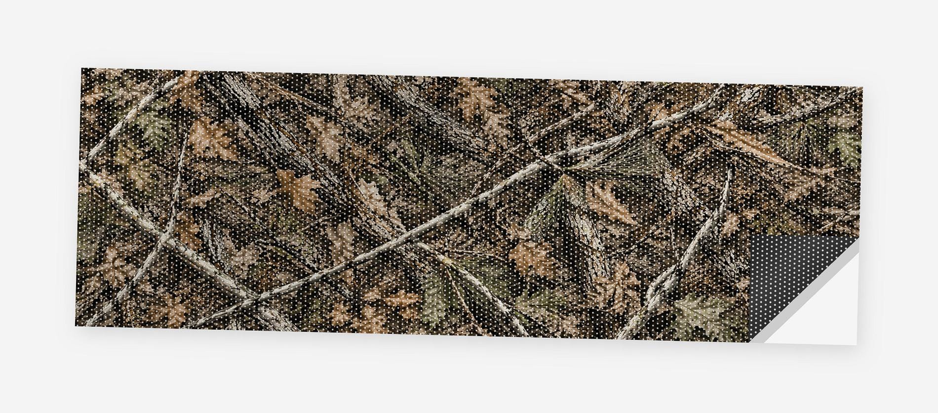 Woodland Camo 68 x 18.5 inch perforated vinyl truck decal printed flat on white, corner folded up showing the perforation pattern and liner