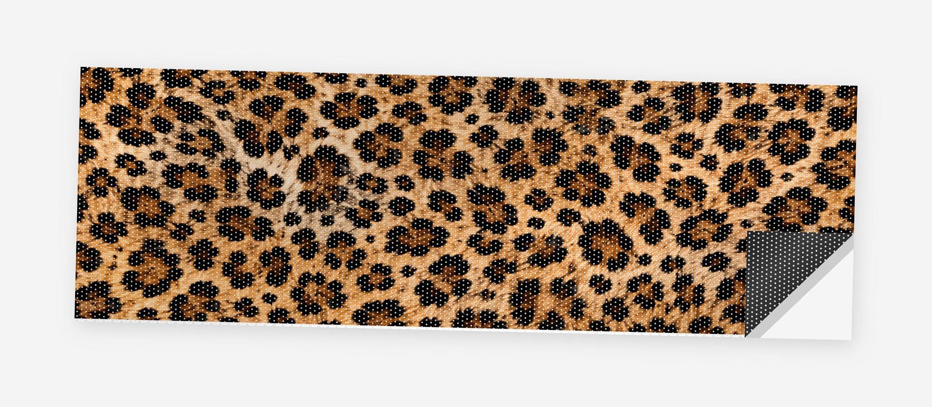Leopard Print 68 x 18.5 inch perforated vinyl truck decal printed flat on white, corner folded up showing the perforation pattern and liner