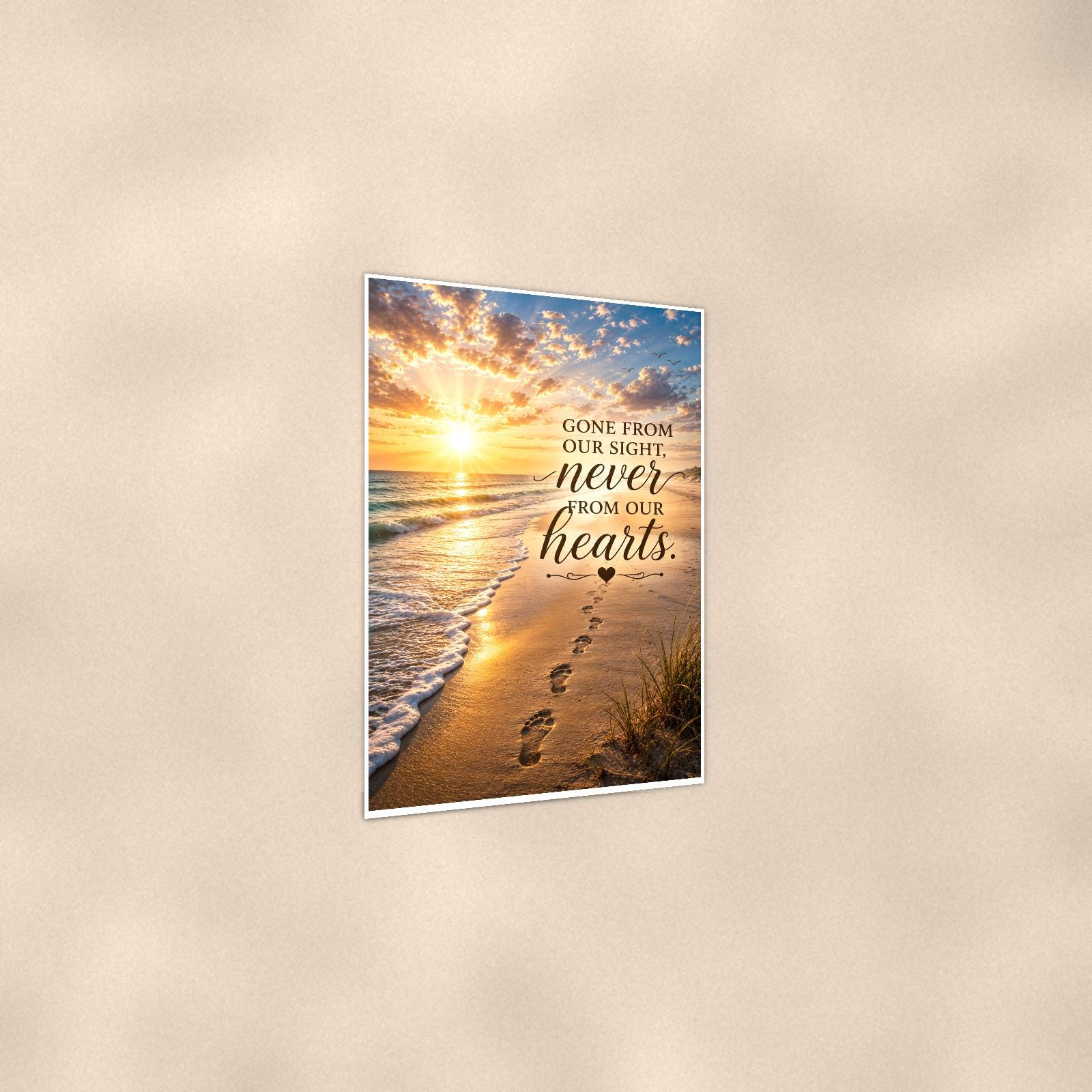 Footprints in the sand at sunset memorial art titled "Gone from our sight, never from our hearts" on a 24x36 inch luster poster print with a clean white border, shown at a three-quarter angle on the wall