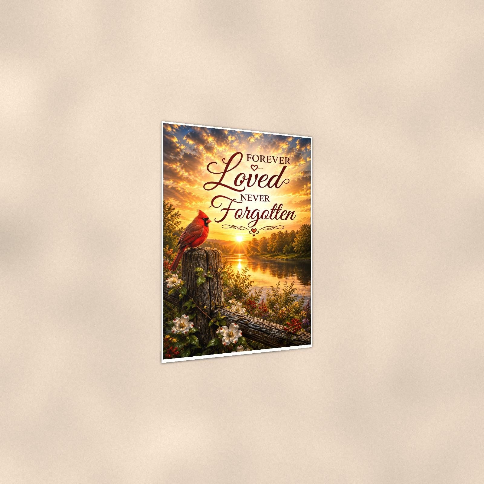 Cardinal at sunrise over the river memorial art titled "Forever Loved Never Forgotten" on a 24x36 inch luster poster print with a clean white border, shown at a three-quarter angle on the wall