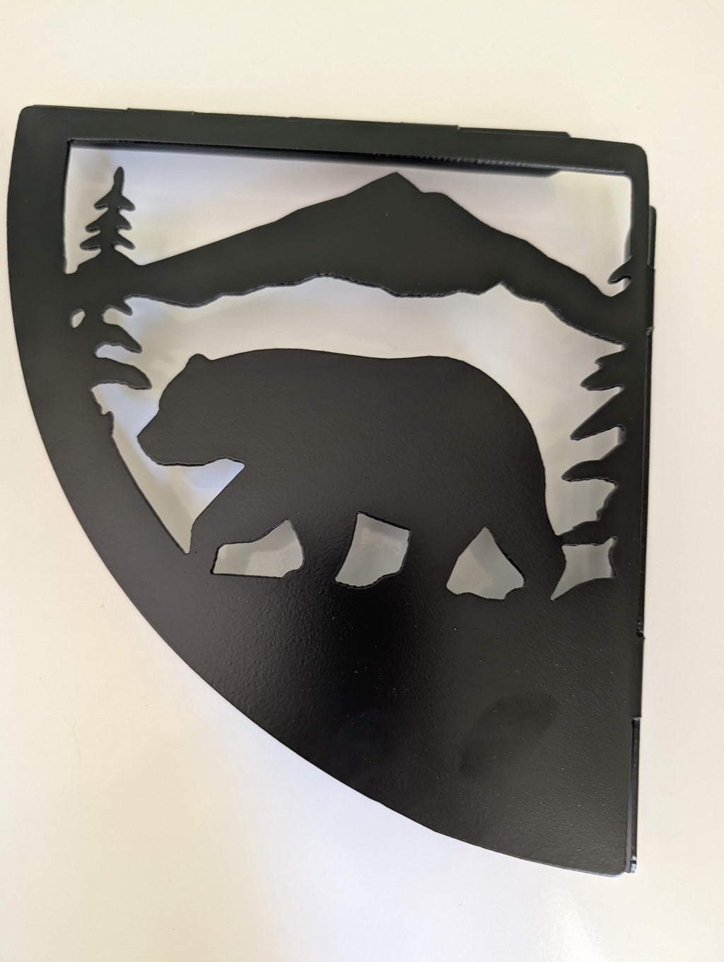 Close-up of the mountain bear shelf bracket showing the plasma cut bear walking under a mountain ridge with pine trees