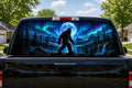 Bigfoot Northern Lights perforated rear-window decal installed on a pickup truck back glass, showing a sasquatch under a full moon with green and purple aurora over snowy mountains and a waterfall