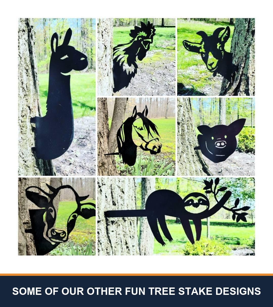 A sampler grid of other TKG metal tree and garden stake designs, shown staked in flower beds and mounted on trees, posts and mailboxes. Captioned “some of our other fun tree stake designs” — these are other designs we make, not what is included with this listing.