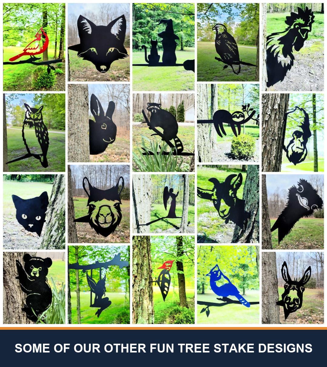 A sampler grid of other TKG metal tree and garden stake designs, shown staked in flower beds and mounted on trees, posts and mailboxes. Captioned “some of our other fun tree stake designs” — these are other designs we make, not what is included with this listing.