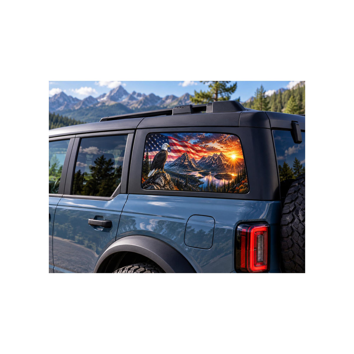 Ford Bronco rear side window with a perforated decal of a bald eagle perched on a rock in front of a waving American flag over a mountain lake at sunset, applied to the outside of the glass.