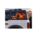 Ford Bronco rear side window with a perforated decal of a firefighter in full turnout gear standing before an American flag and a working structure fire, a fire truck and ladder in the background, applied to the outside of the glass.