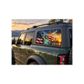 Ford Bronco rear side window with a perforated decal of the Statue of Liberty holding her torch in front of a waving American flag and the New York City skyline at sunset, applied to the outside of the glass.