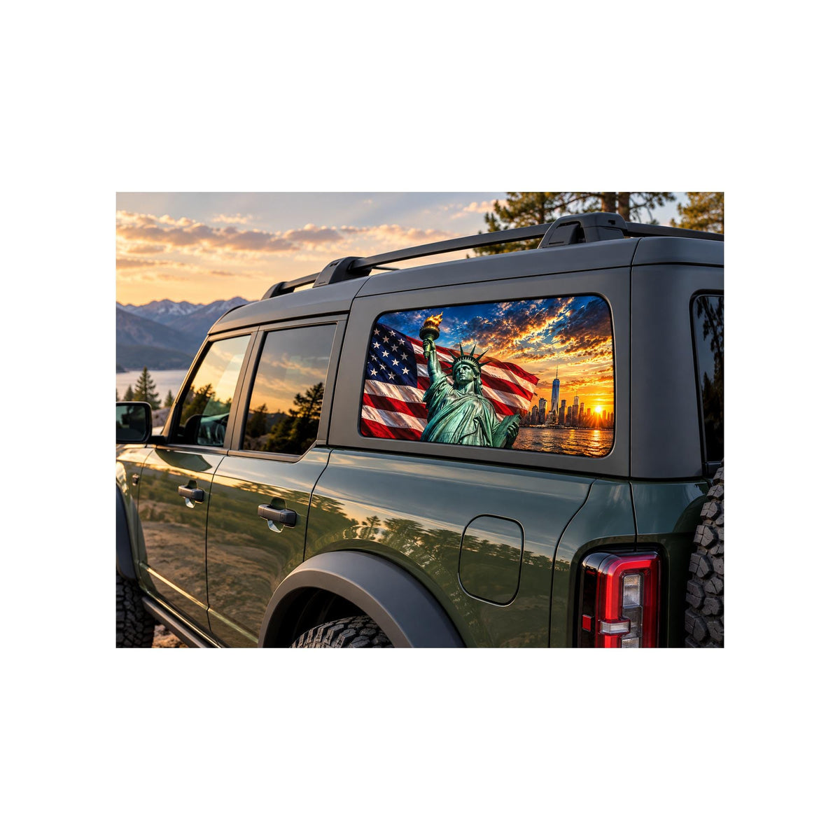 Ford Bronco rear side window with a perforated decal of the Statue of Liberty holding her torch in front of a waving American flag and the New York City skyline at sunset, applied to the outside of the glass.