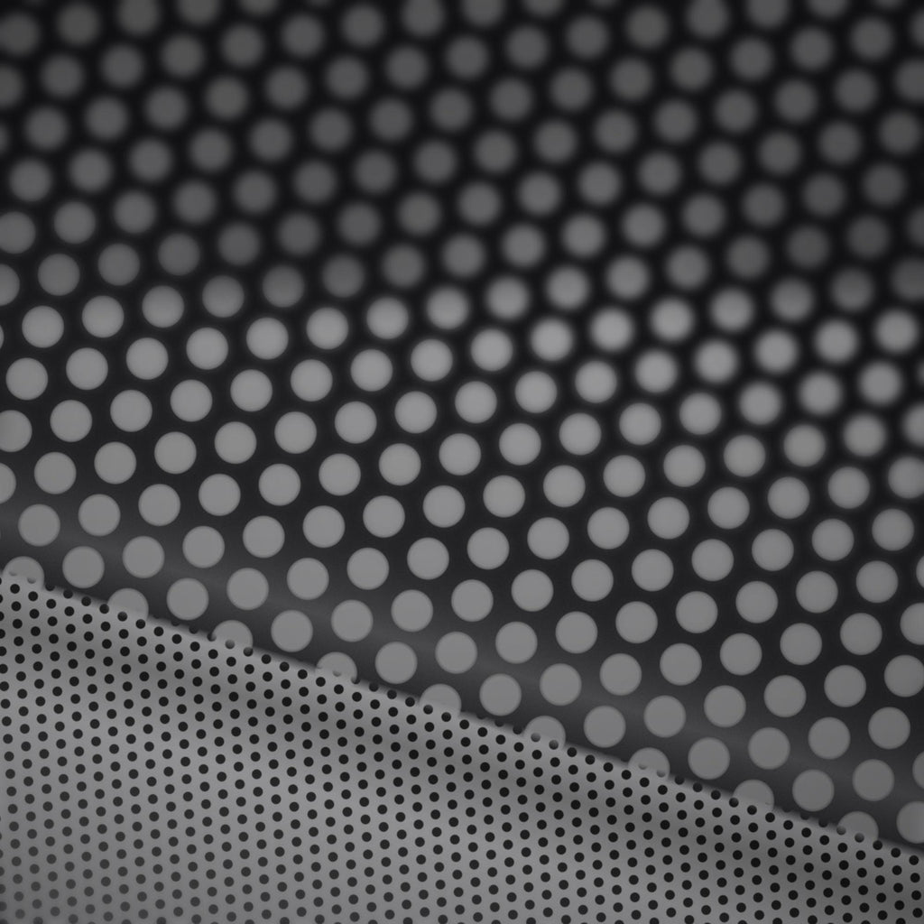 Extreme macro close-up of the perforated vinyl surface showing the printed face and the micro-perforation holes that create the one-way see-through effect.