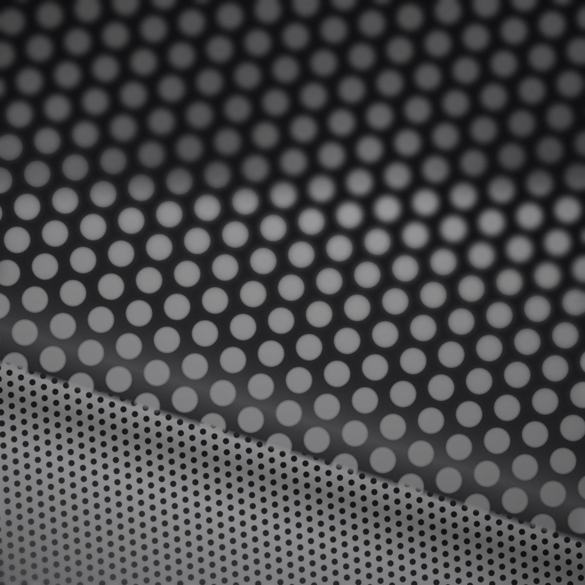 Extreme macro close-up of the perforated vinyl surface showing the printed face and the micro-perforation holes that create the one-way see-through effect.