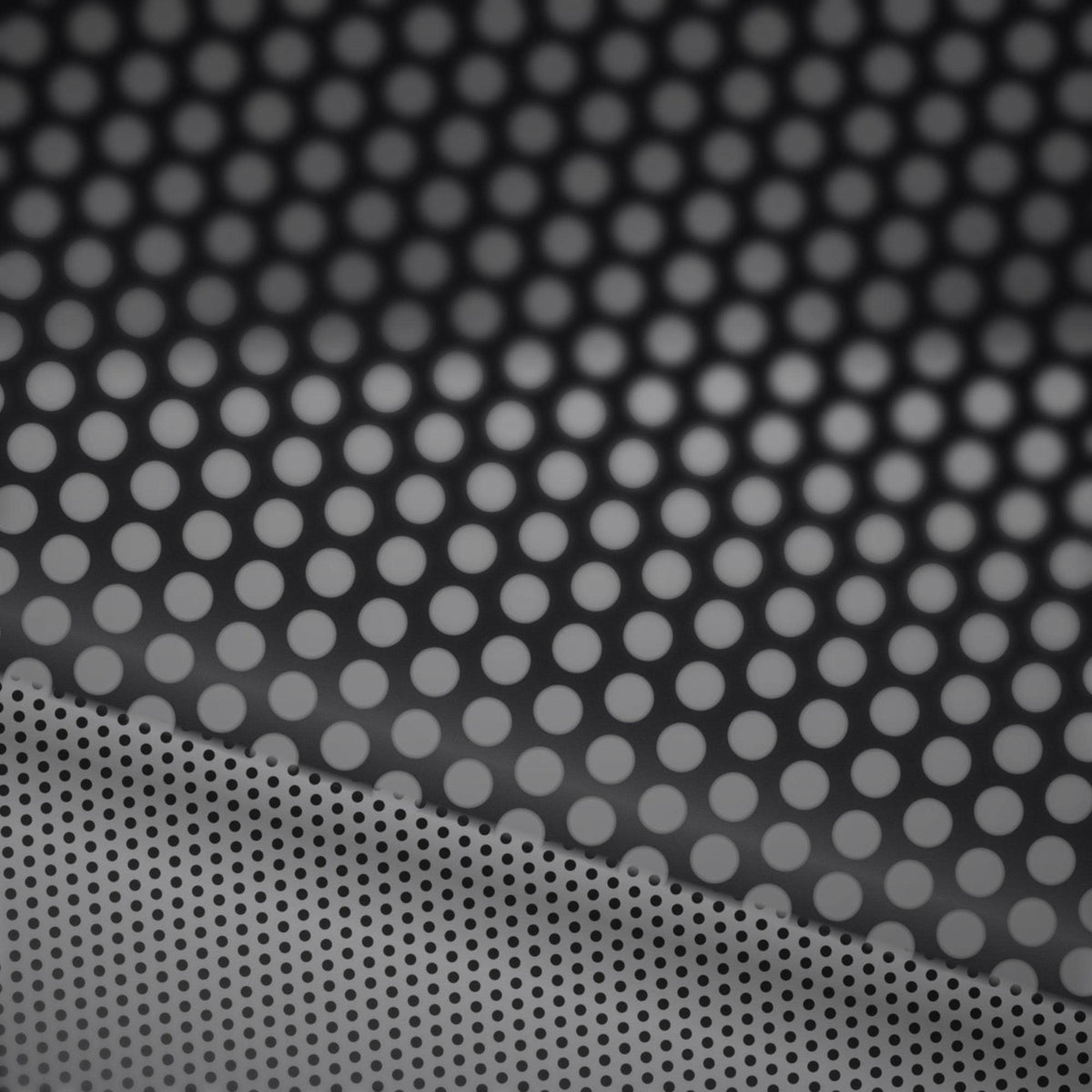 Extreme macro close-up of the perforated vinyl surface showing the printed face and the micro-perforation holes that create the one-way see-through effect.